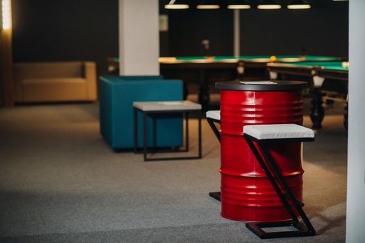 table and two chairs near the green-covered billiard table with balls in the billiard club.