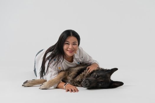 Happy friends. Beauty woman and shepherd dog looks at camera embracing together in studio. Cut out on white background. Friendship concept.