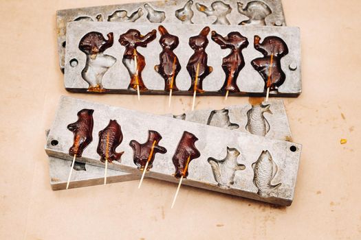 Making sugar lollipops at home.A taste of our childhood.Cockerel lollipops on a stick.Sugar caramel.