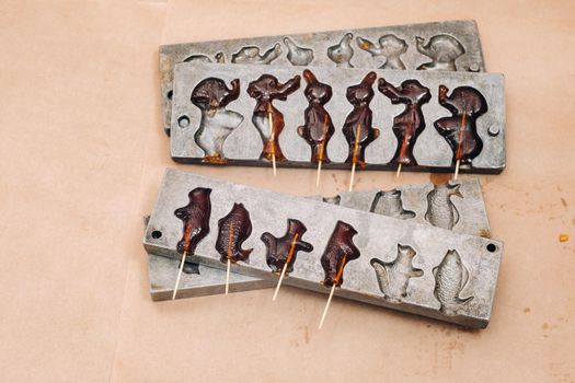 Making sugar lollipops at home.A taste of our childhood.Cockerel lollipops on a stick.Sugar caramel.