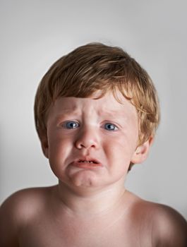 In need of some comforting. Upset red-headed toddler getting ready to cry
