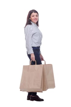 Full length side view of young businesswoman holding shopping bags and looking at camera