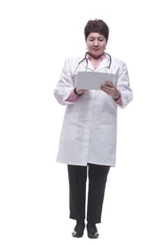 in full growth. female doctor reading a message on a digital tablet. isolated on a white background