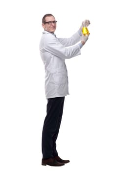 side view. a young scientist looking at a liquid in a laboratory bottle . isolated on a white