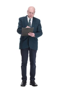 in full growth. serious business man with glasses taking notes on the clipboard. isolated on a white background.