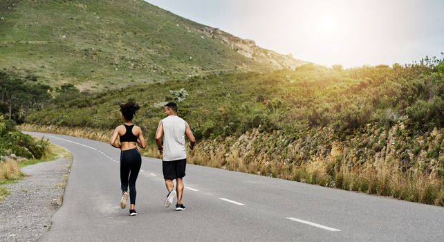 Leading a physically active lifestyle together. Rearview shot of a sporty young couple exercising together outdoors