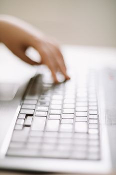 Close-up of male hands typing on laptop keyboard indoors. Businessman working in office or student browsing information. input data for information analysis and sending an email message.