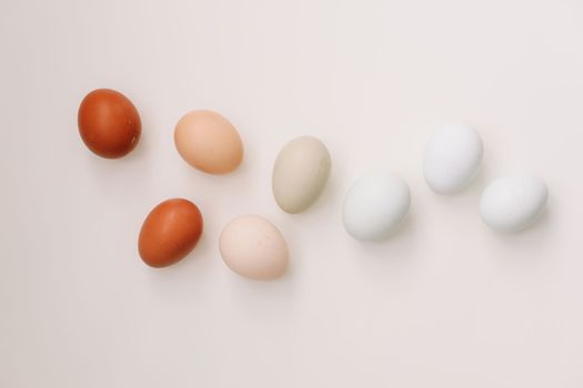 Chicken eggs of natural shades and colors a white background. Healthy organic food, natural farmer's products concept. Happy Easter background. Selective focus.