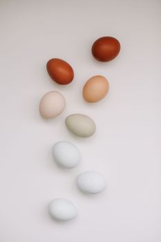 Chicken eggs of natural shades and colors a white background. Healthy organic food, natural farmer's products concept. Happy Easter background. Selective focus.