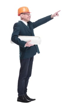 side view. smiling architect with a roll of drawings pointing ahead . isolated on a white background.
