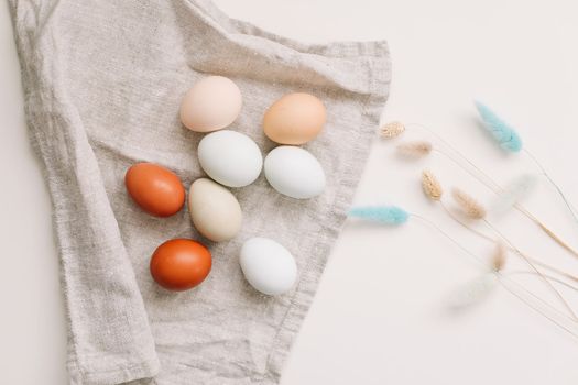 Chicken eggs of natural shades and colors a white background. Healthy organic food, natural farmer's products concept. Happy Easter background. Selective focus.