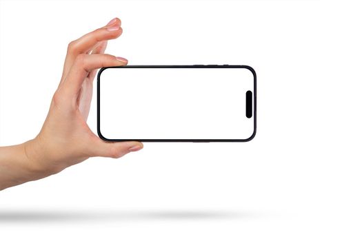 Phone in hand on a white background. A woman's hand holds a new modern phone in her hand on a white background with a blank white screen