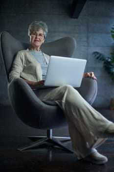 woman sitting in a chair in Art Nouveau style. Business, elegant businesswoman working on laptop . Interior, furniture.