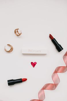 Greeting card with word February. Red ribbon and heart on white wooden background, flat lay.