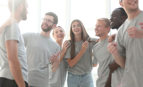 close up. a group of diverse young men in grey t-shirts standing together.