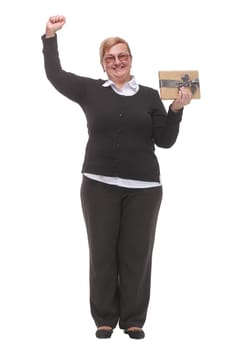 Nice happy woman pointing up with her finger while holding a present box. Concept of positive emotions.