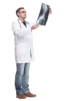 in full growth. qualified doctor looking at an x-ray. isolated on a white background.