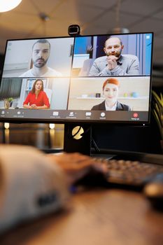 Manager explaining company investment strategy to remote colleagues during online videocall meeting conference. Diverse corporate team working late at night in startup office. Business concept