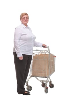 Full length shot of a mature woman pushing a shopping cart with shopping bags and looking at camera