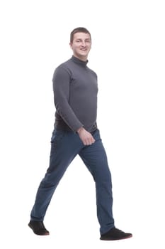 young man in casual clothing striding forward. isolated on a white background.