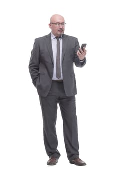 in full growth. business man with a smartphone.isolated on a white background.