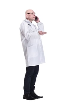 side view . man doctor talking on a mobile phone. isolated on a white background.