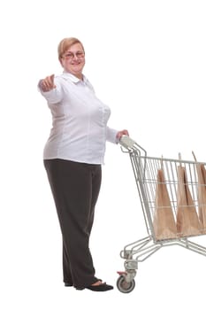 Full length portrait of a woman pushing a shopping trolley isolated on white background