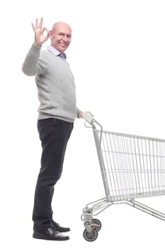 in full growth. a happy man with a shopping cart. isolated on a white background.