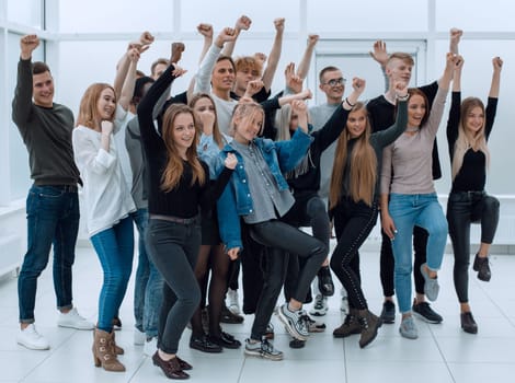 in full growth. a group of happy youths who are pointing ahead