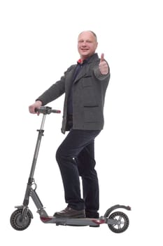 in full growth. happy casual man with electric scooter .isolated on a white background.