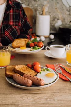Cooked English breakfast with coffee and orange juice in kitchen at home