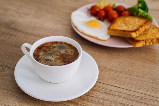 Close up cup of black coffee with homemade breakfast on wooden table
