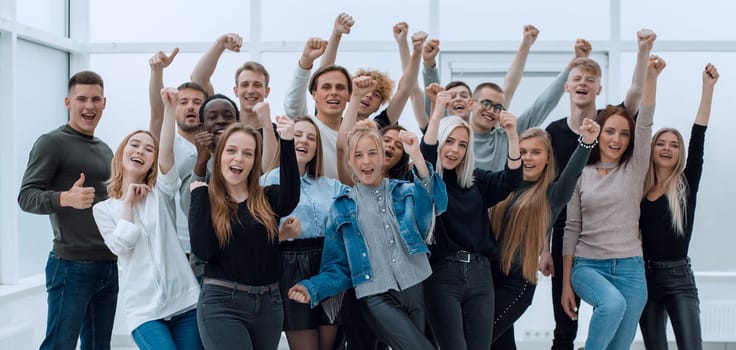 in full growth. a group of happy youths who are pointing ahead