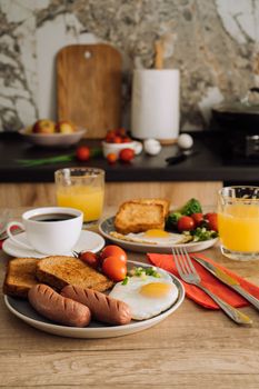 Home cooked English breakfast with cup of black coffee and orange juice in kitchen