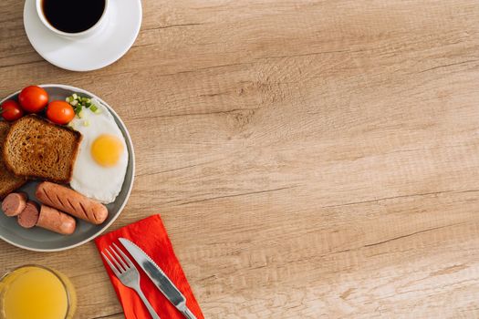 English breakfast with black coffee and orange juice on wooden table with copy space