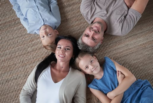 Top view portrait of happy family with kids, lying on the floor