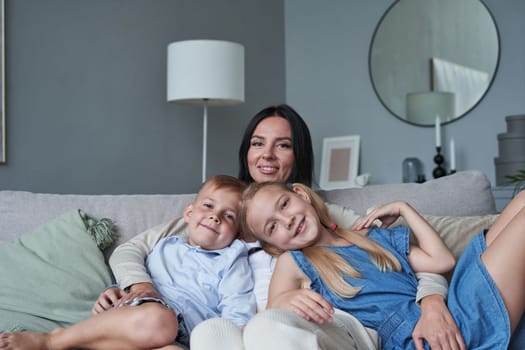 portrait of mother daughter and son at home on sofa
