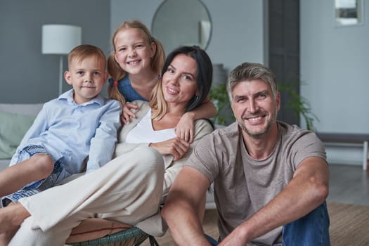 Family sitting in living room smiling at home