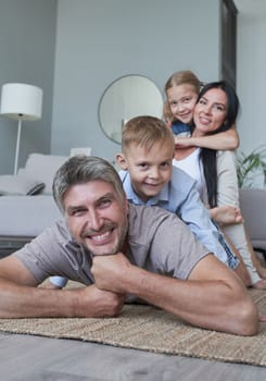 Young family of four having fun at home smiling