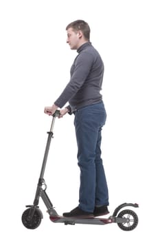 in full growth. casual young man with an electric scooter. isolated on a white background.