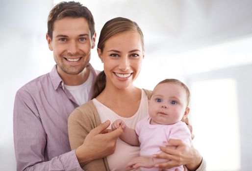 Our happy little family. Portrait of a young couple holding their baby girl