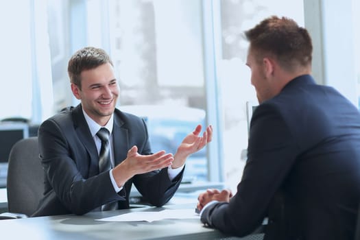 business partners talking while sitting at your Desk . photo with copy space