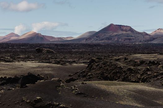 Black volcanic landscape of Timanfaya National Park in Lanzarote. Popular touristic attraction in Lanzarote island, Canary Islands, Spain