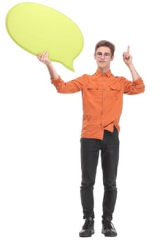 Attractive young man is holding a speech bubble, looking at camera and smiling, on white background