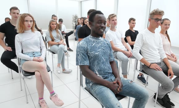 group of diverse young people sitting in a conference room. photo with copy space