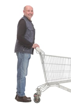 Smiling mature man holding shopping bags walking forward isolated on white background