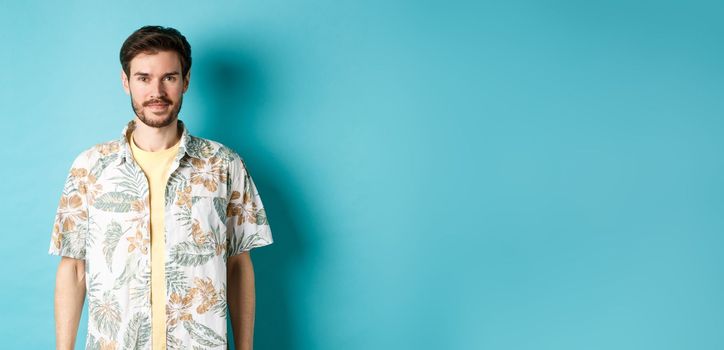 Happy handsome guy smiling, wearing hawaiian shirt on vacation. Concept of summer holiday.