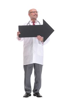 Mature doctor holding a black arrow pointing right isolated on white background smiling at camera