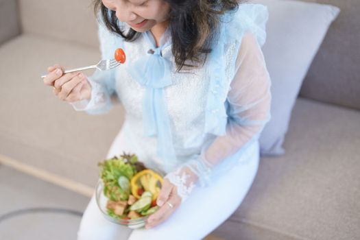 Portrait of an elderly Asian woman taking care of her health by eating salad