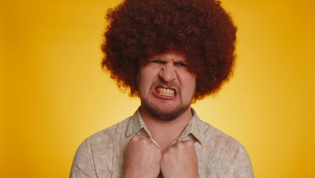 Dissatisfied man shaking head no, asking reason of failure, expressing disbelief irritation, feeling bored, disappointed in result, bad news. Hipster guy isolated on yellow studio wall background